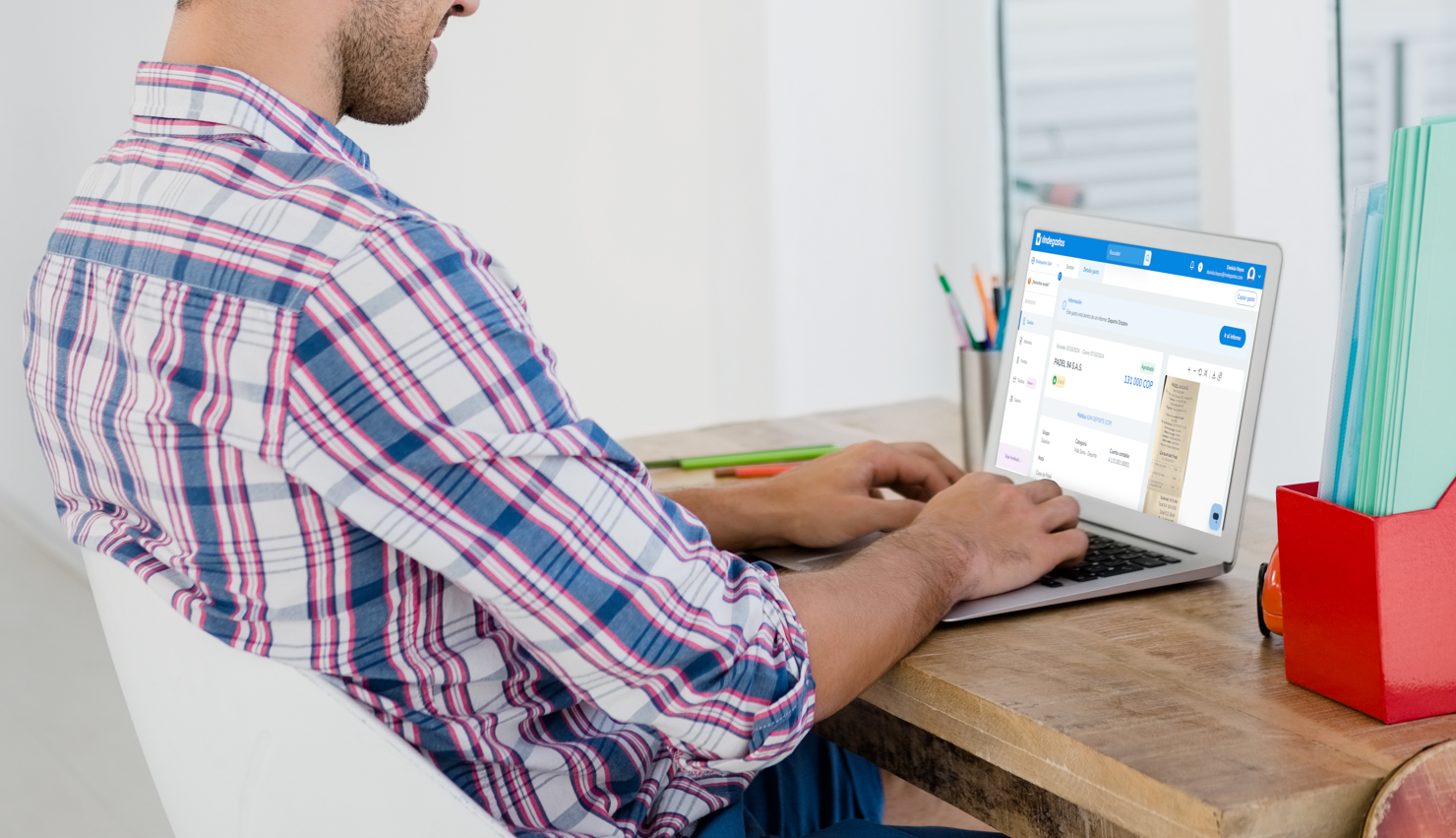 Persona usando una laptop mientras revisa un gasto en Rindegastos, mostrando una factura de compra con detalles de pago y categoría