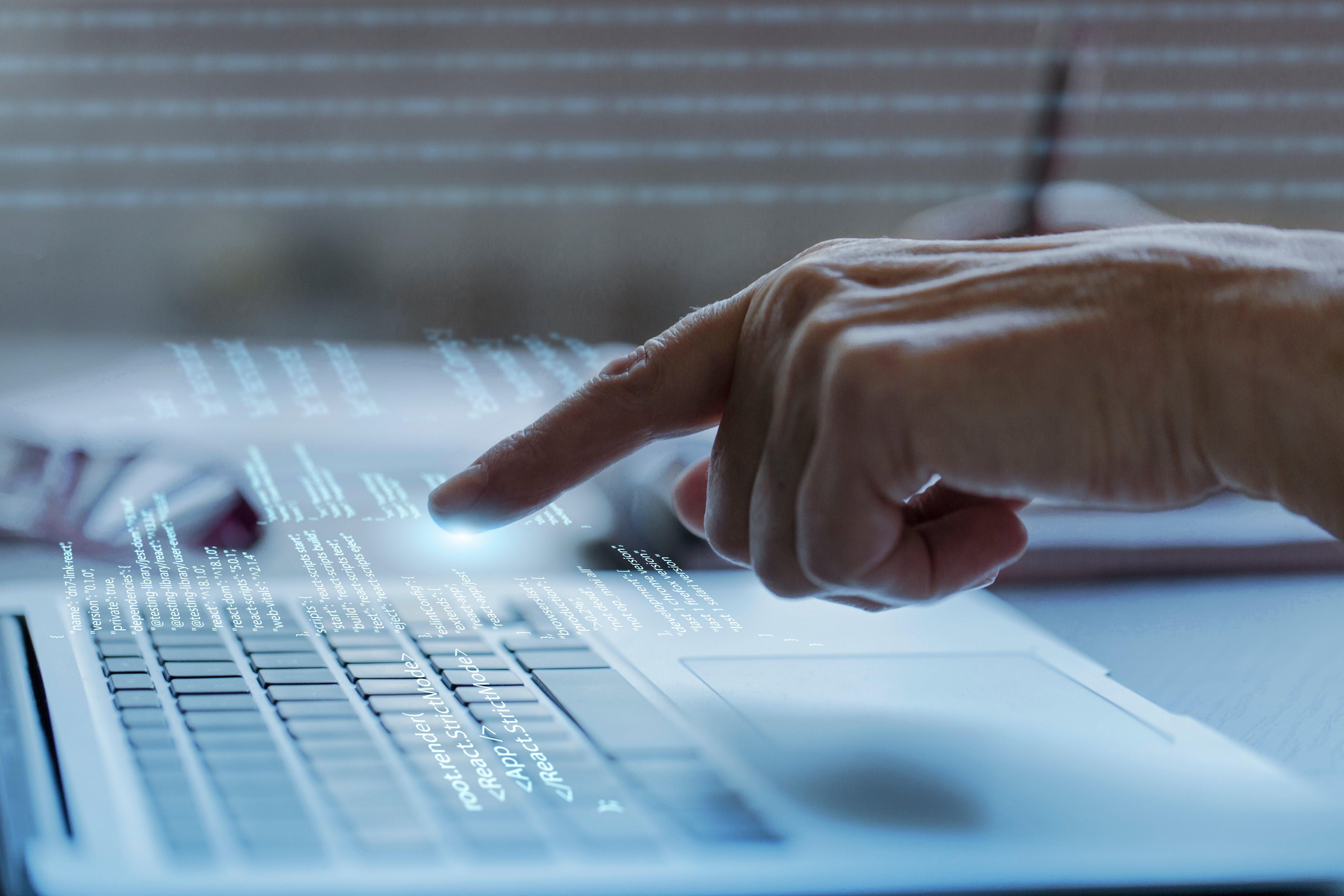 Mano interactuando con datos proyectados digitalmente sobre un teclado de laptop. Simboliza el análisis automatizado y el uso de inteligencia artificial en la gestión empresarial.