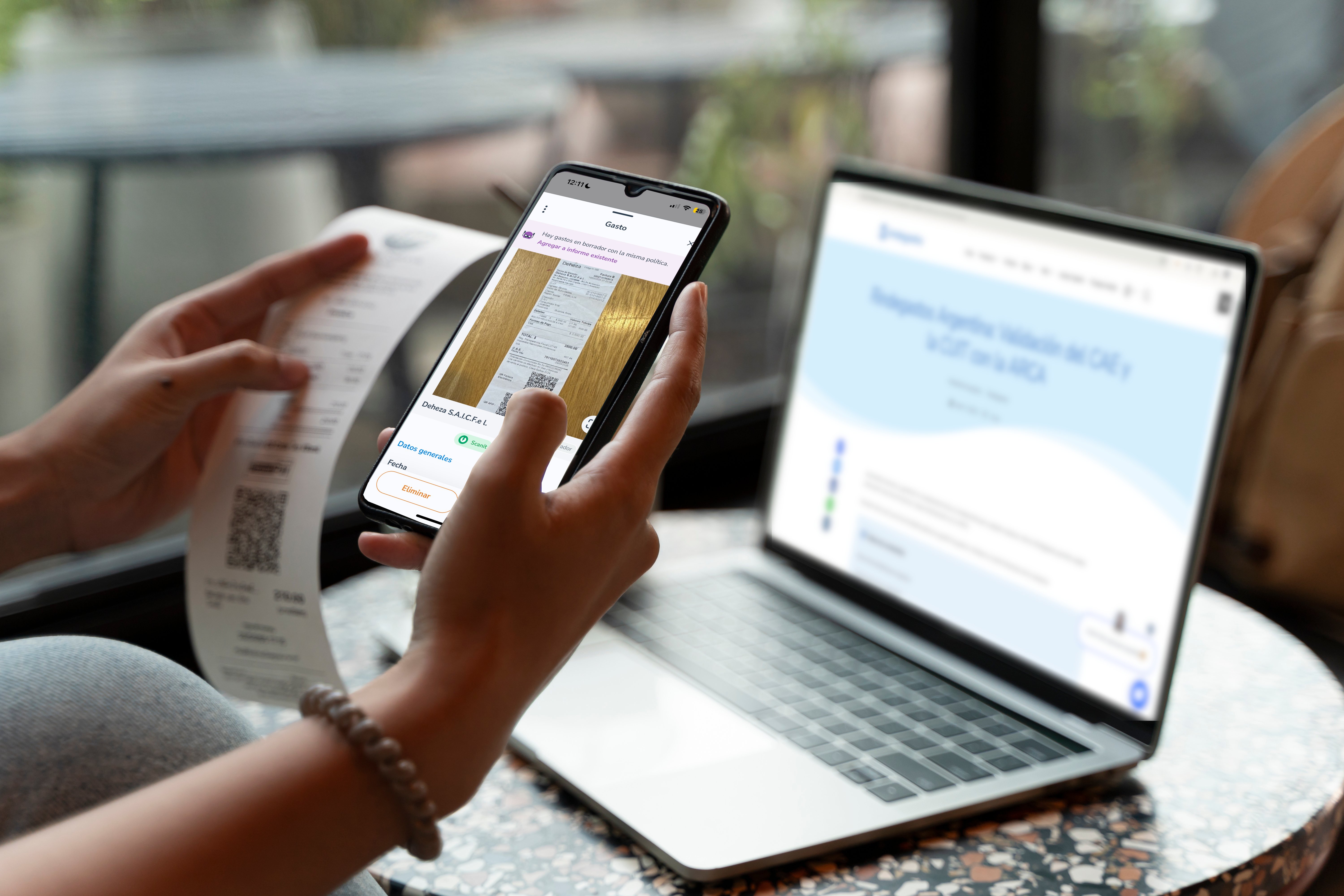 Persona escaneando un comprobante con su celular mientras consulta información fiscal en laptop, ilustrando la automatización del registro de gastos con tecnología OCR y validación con ARCA.