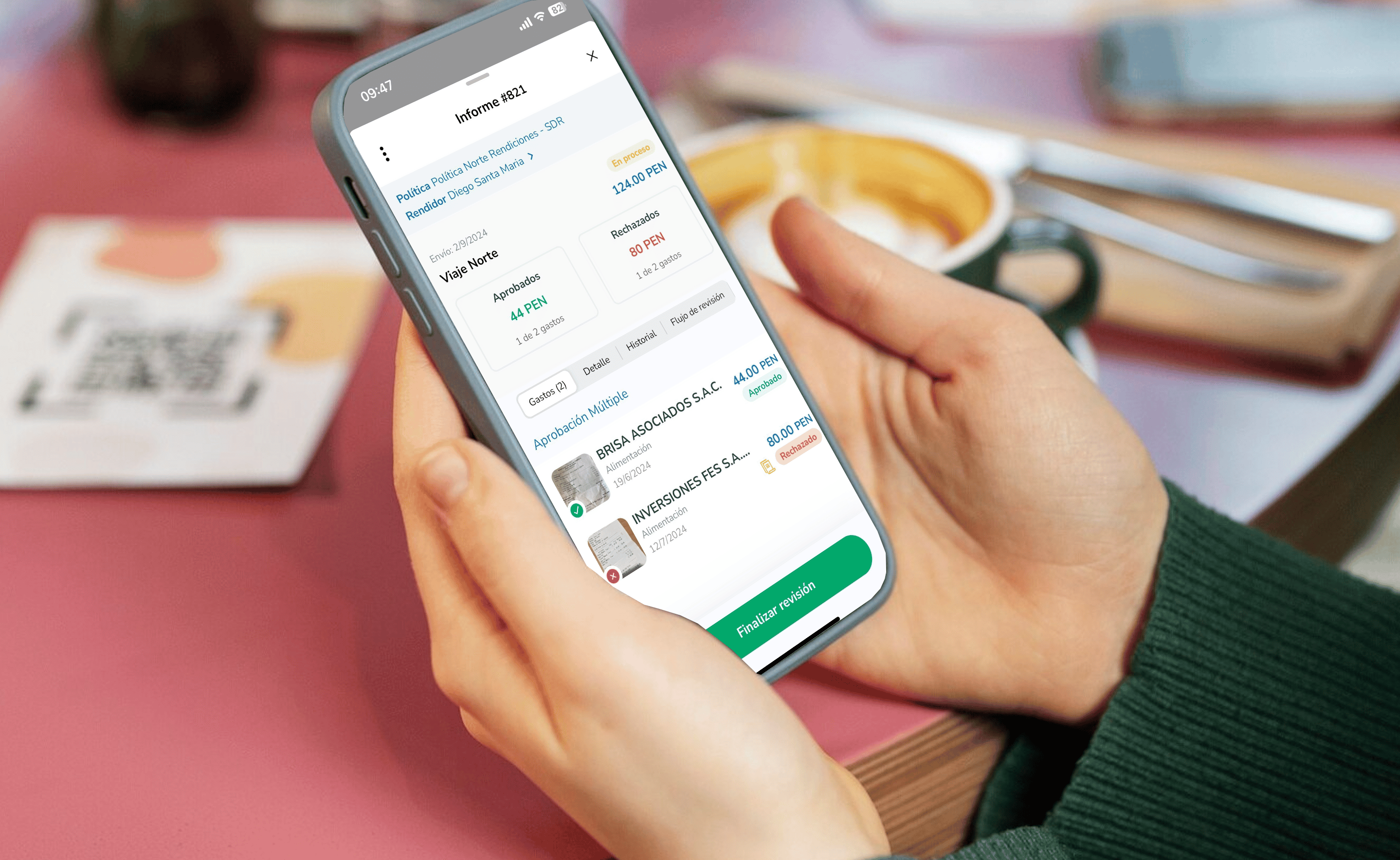 Persona revisando un informe de gastos en su teléfono móvil, con algunos gastos aprobados y rechazados en la pantalla de la app."